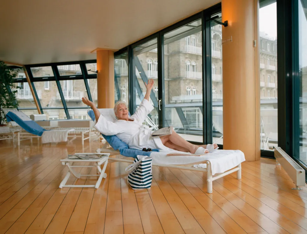 a woman in a bathrobe relaxing on a lounge chair