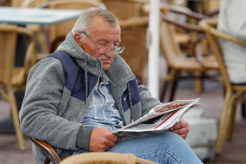 an old man reading a newspaper