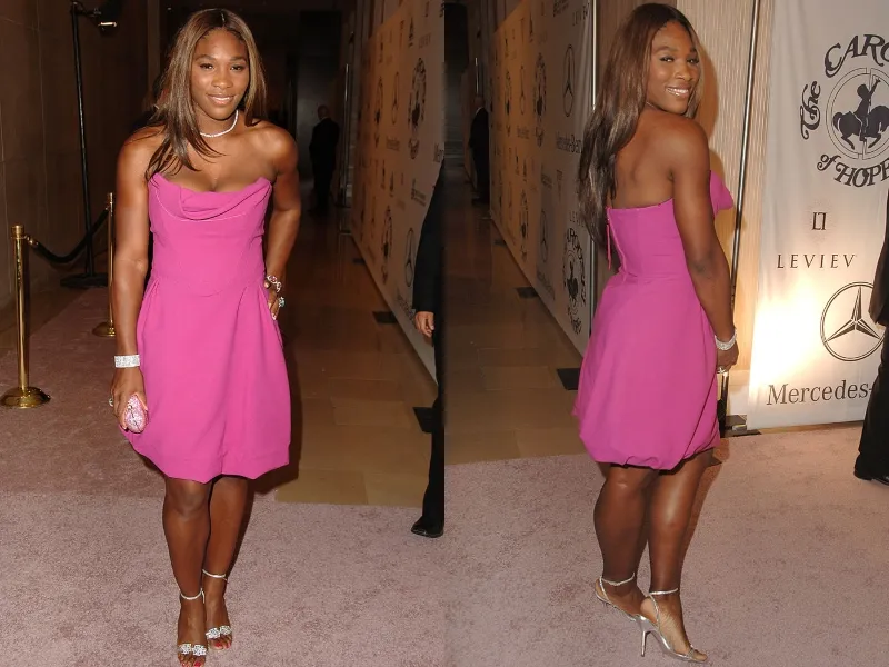 Serena Williams poses in a pink dress and silver heels.
