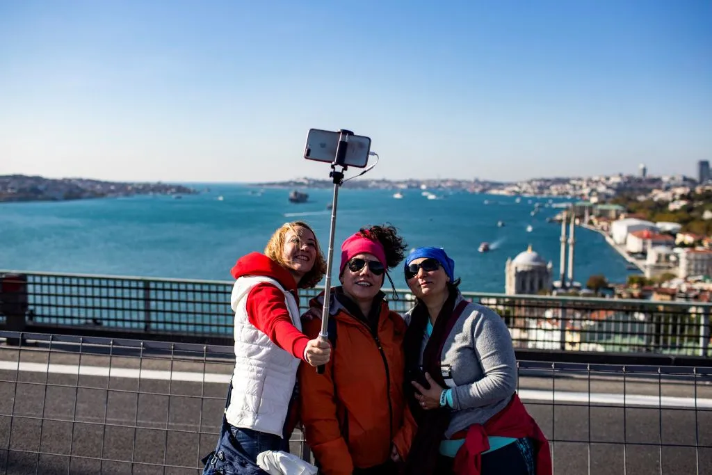 three women taking a selfie on a bridge