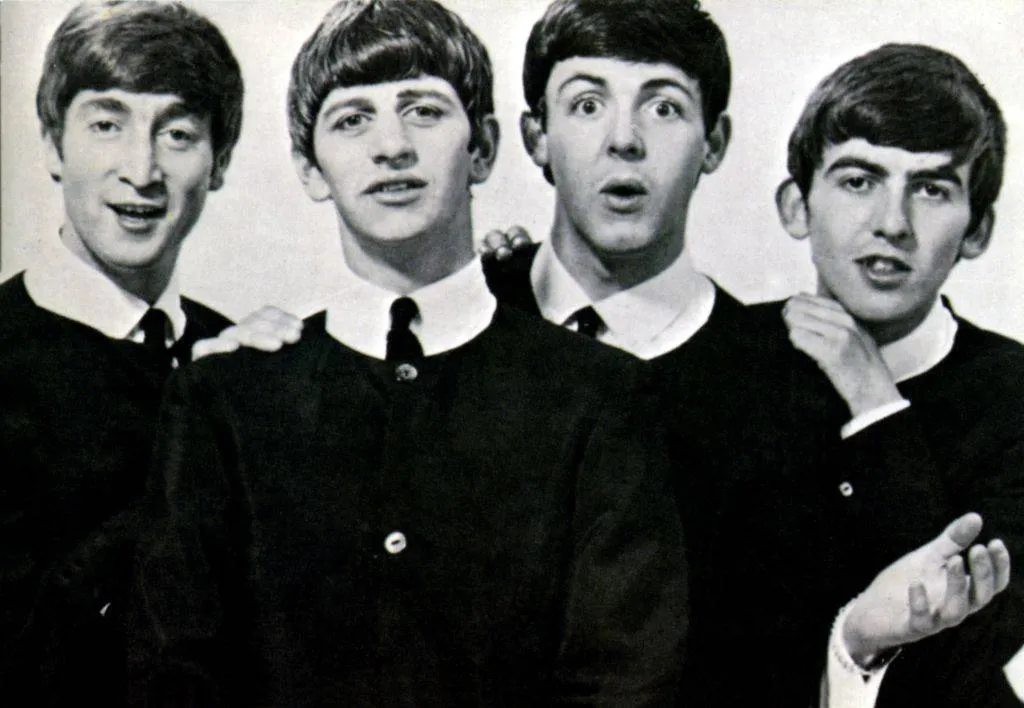 The Beatles pose in their schoolboy look.