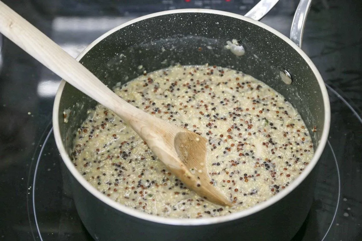 A person stirs quinoa in a pot.