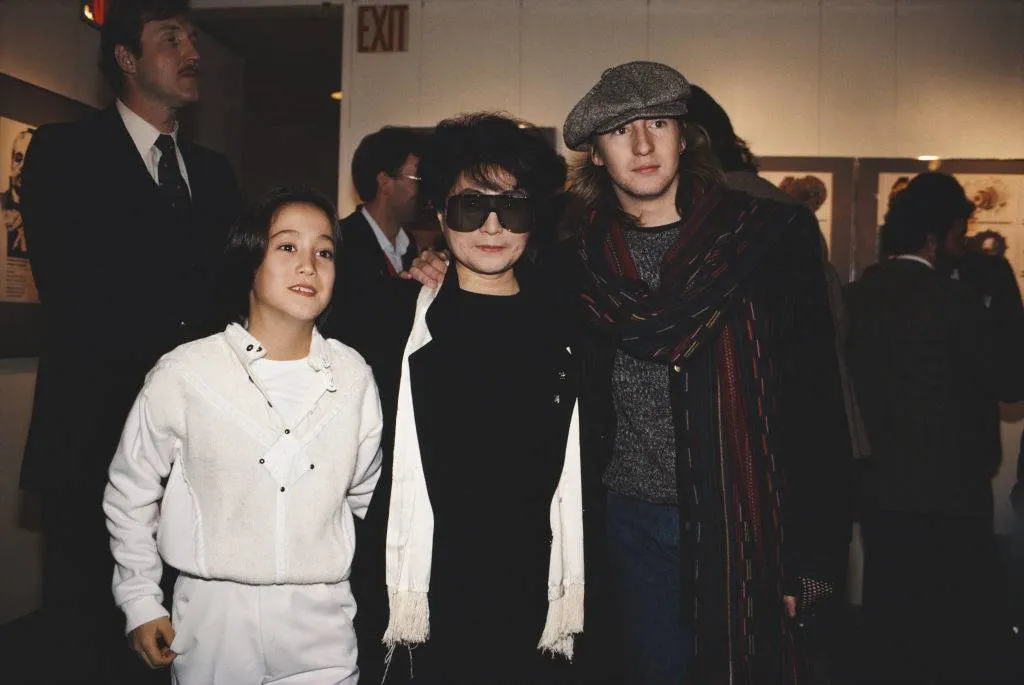 Teenage Julian and young Sean Lennon put their arms around Yoko Ono.