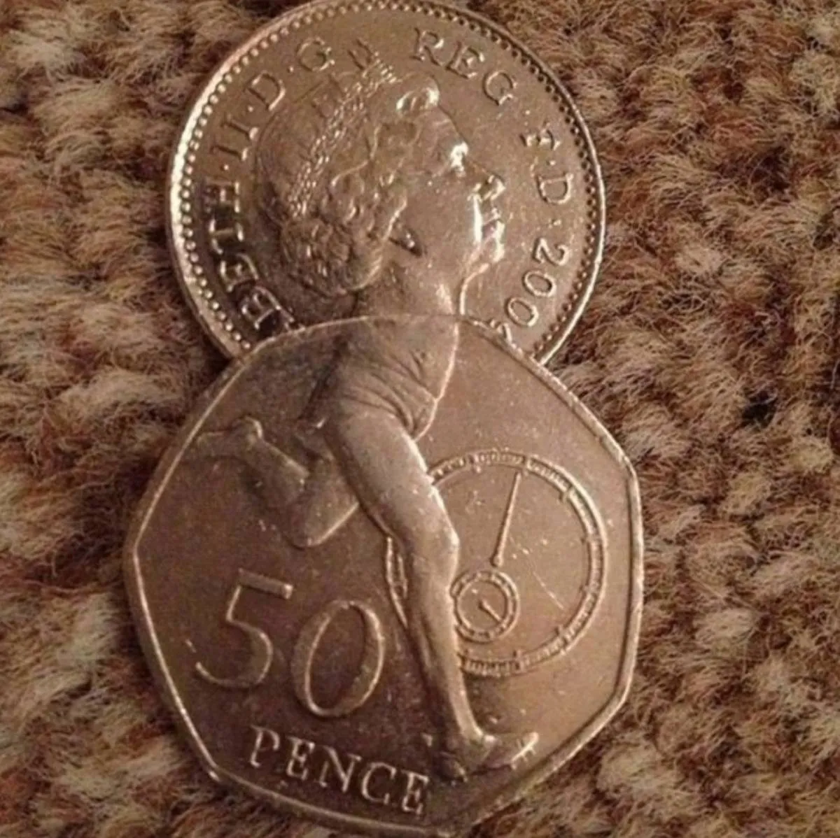 Overlapping british coins make the queen looks like she's just a head, neck and legs