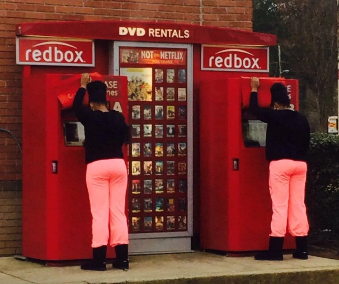 Two women at redbox look exactly the same with same outfits
