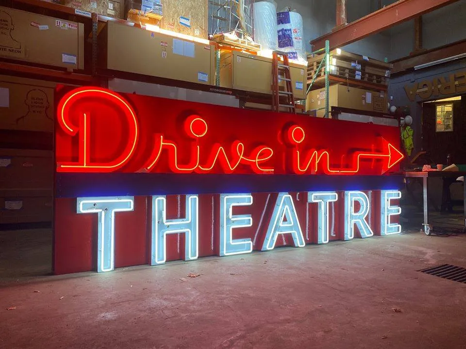 a neon sign that reads drive in theatre