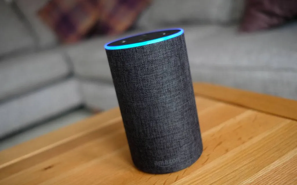 An amazon echo sits on a coffee table.