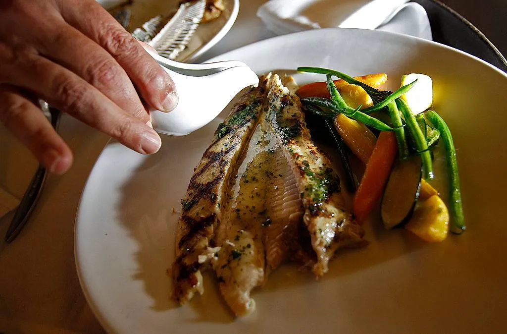 Sauce is poured over a grilled dover sole.