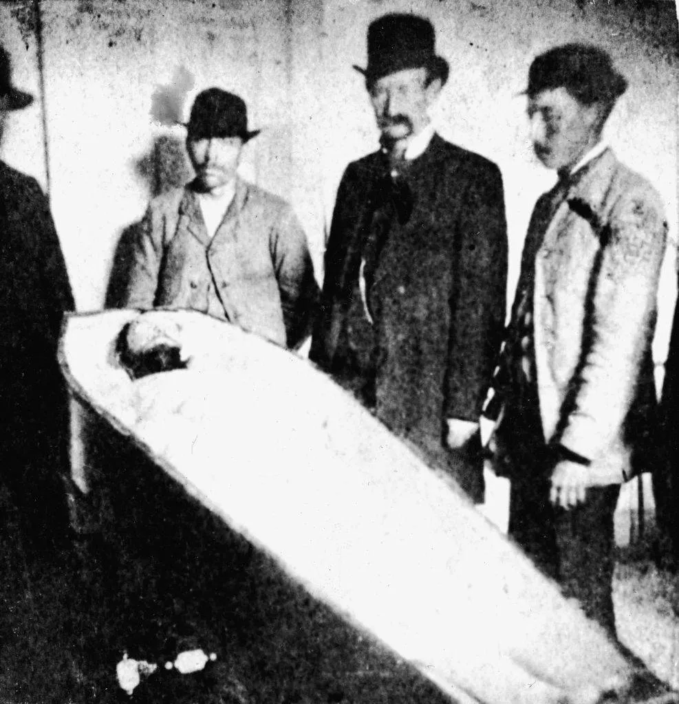 American outlaw Frank James (second from left) and others pose over the dead body of his brother, Jesse James 