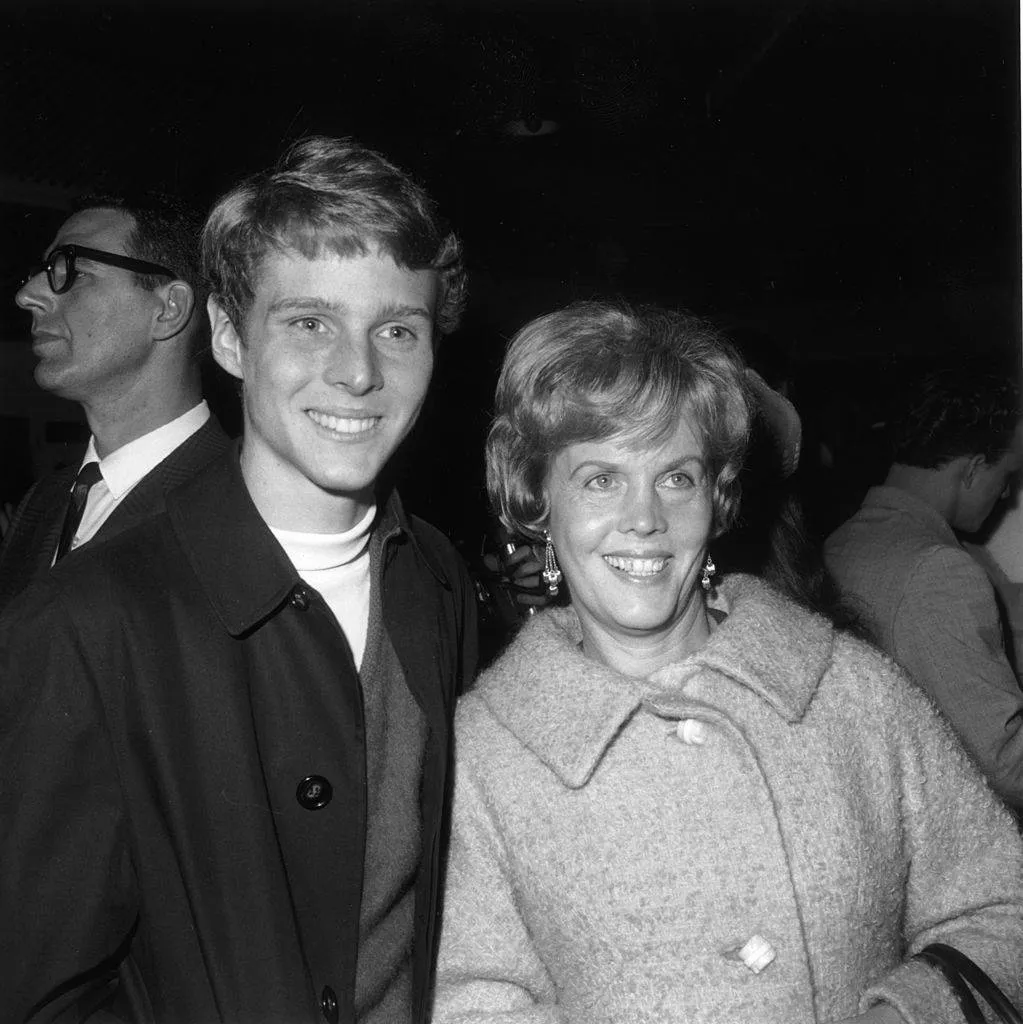 November 1966: American child actor Jay North smiles while standing next to his mother