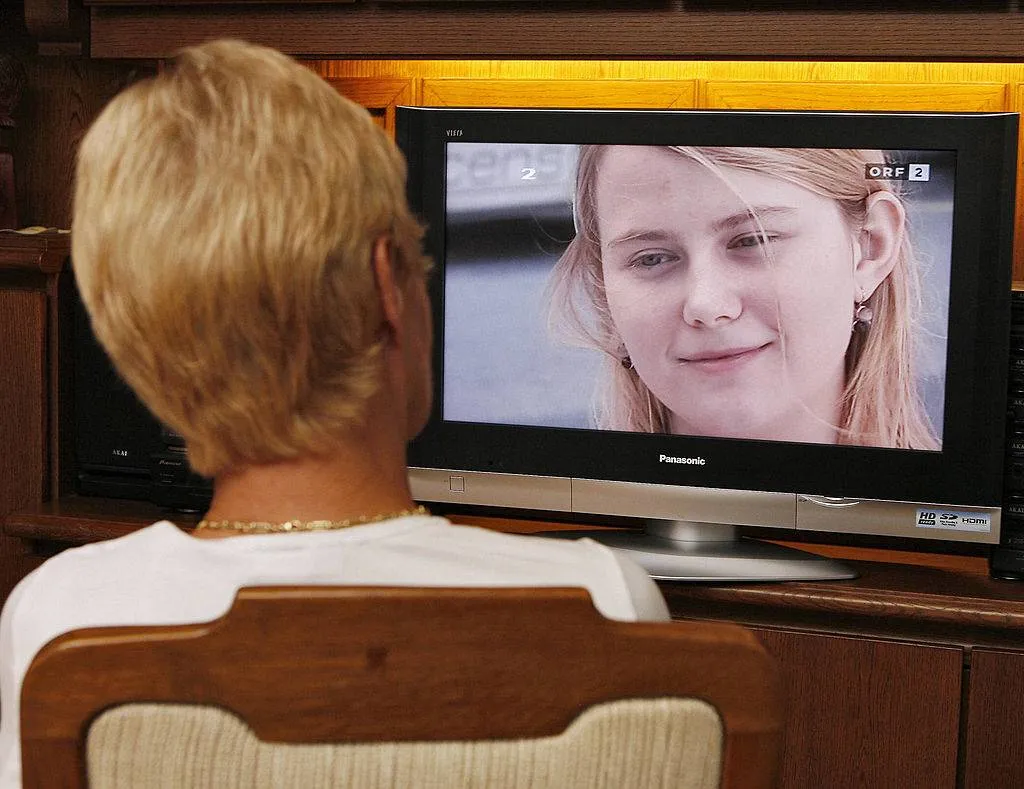 A woman watches on TV, 20 August 2007, an interview of Natascha Kampusch