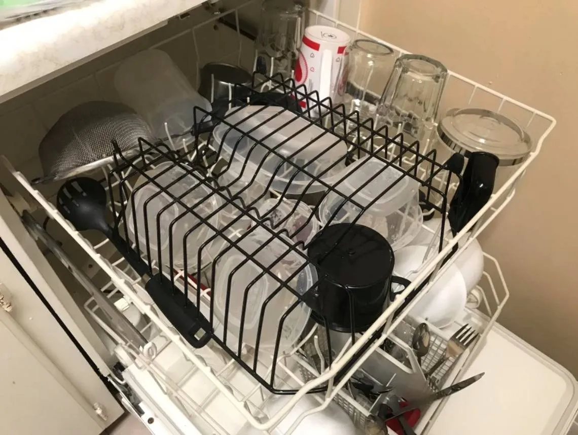 standing dish rack flipped over on top of tupperware containers in dishwasher top rack