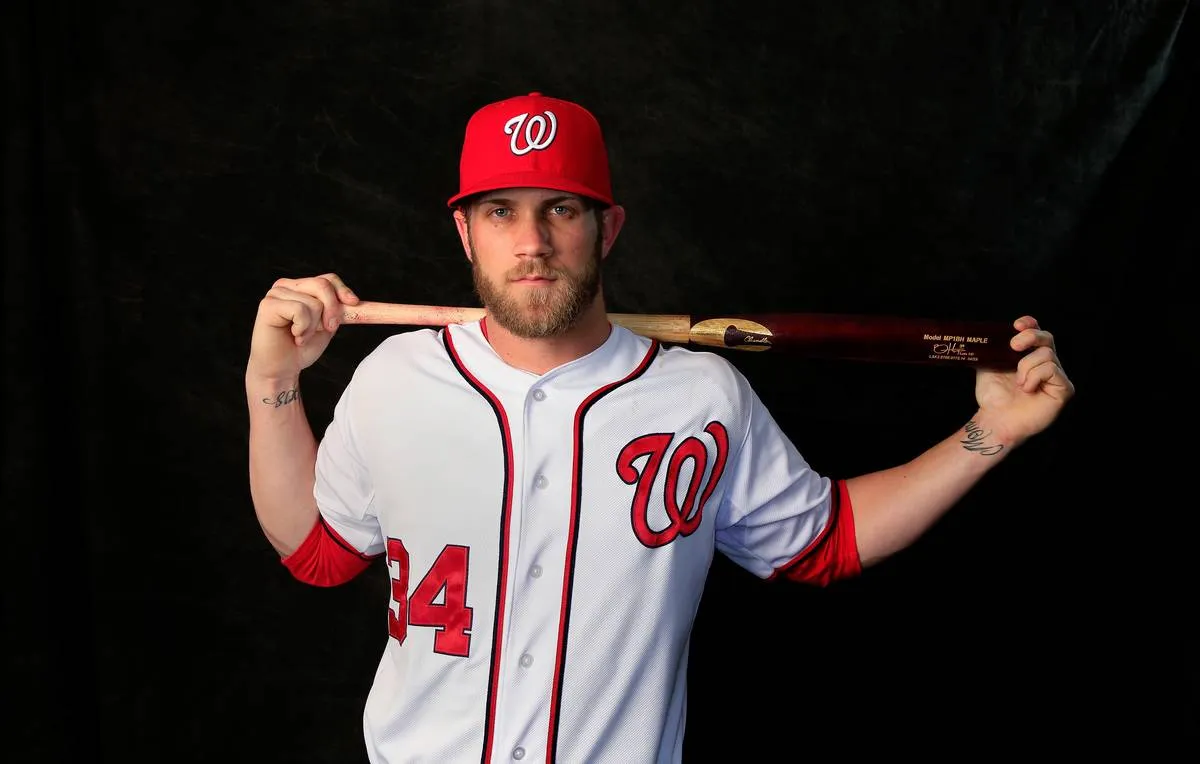 Bryce Harper poses for a photo with his baseball bat over his shoulders.