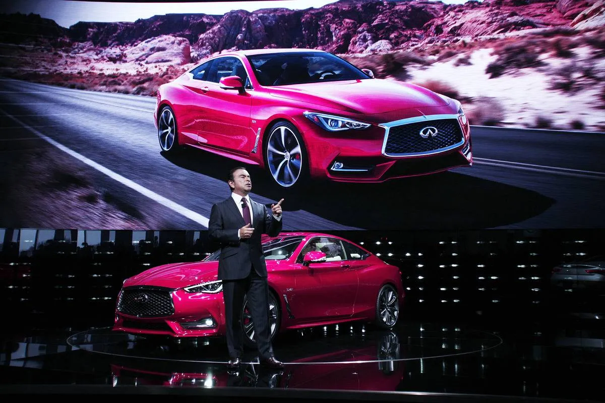 The CEO of Nissan shows the Infiniti Q60 in person and on a giant screen.