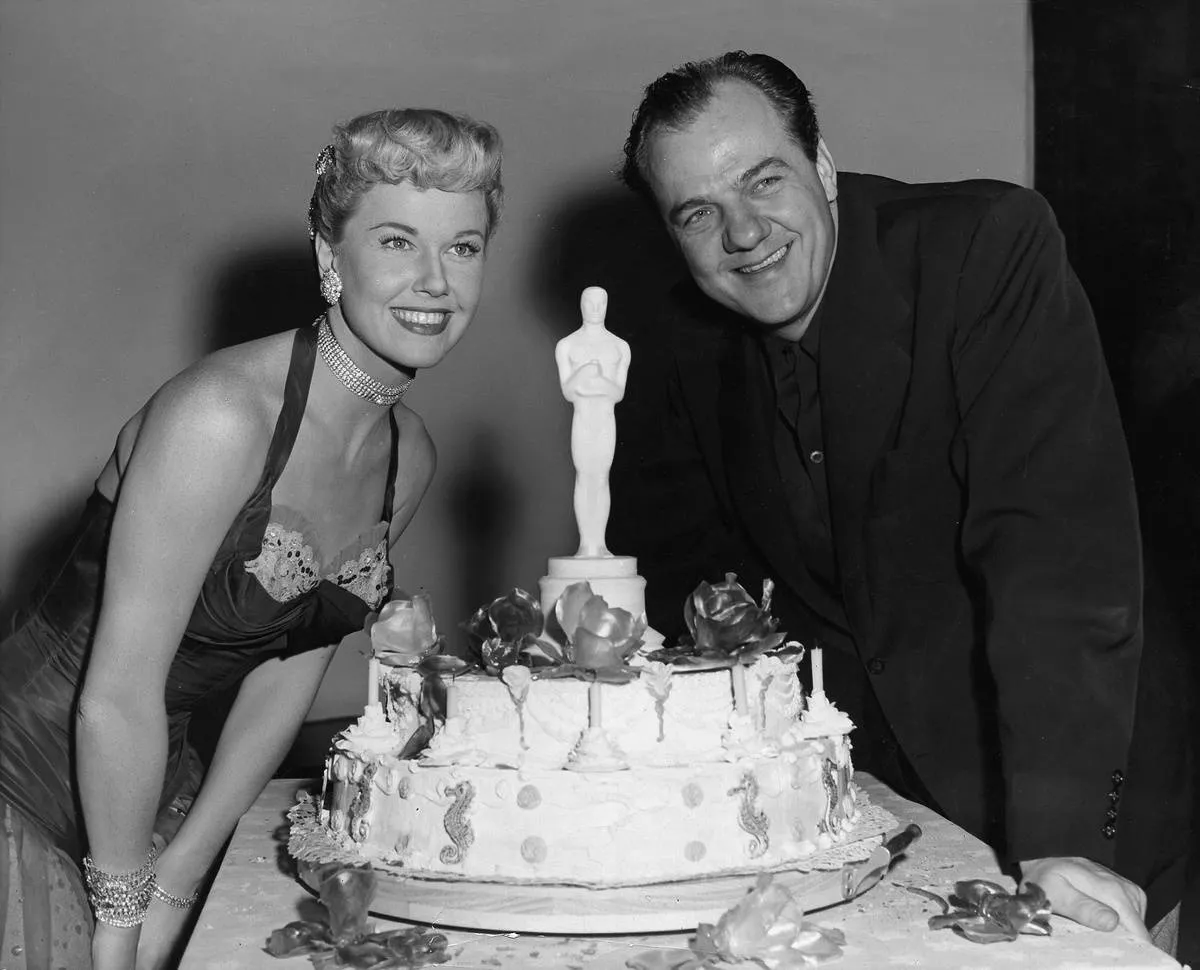 Doris Day and Karl pose next to an Oscars cake.