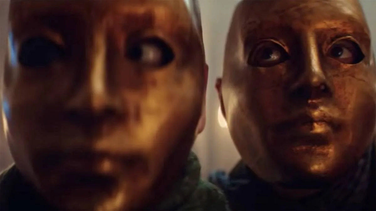 two people in gold masks in cadaver