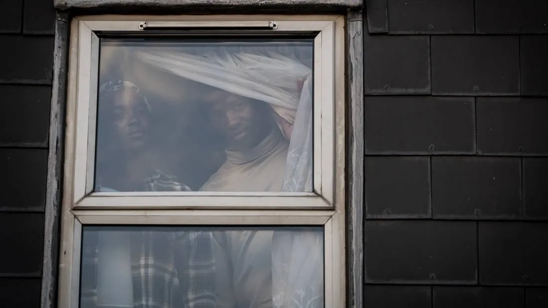 people looking through a window in his house
