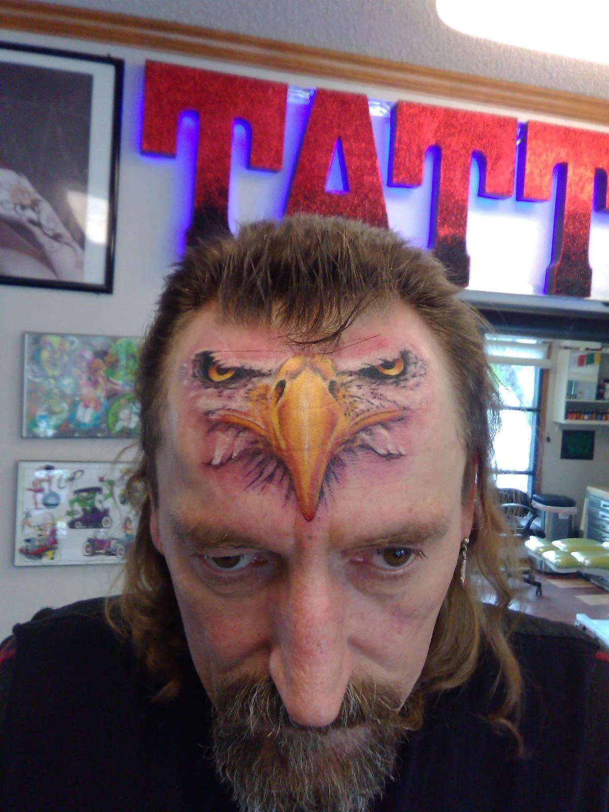 tattoo of eagle face on a man's forehead