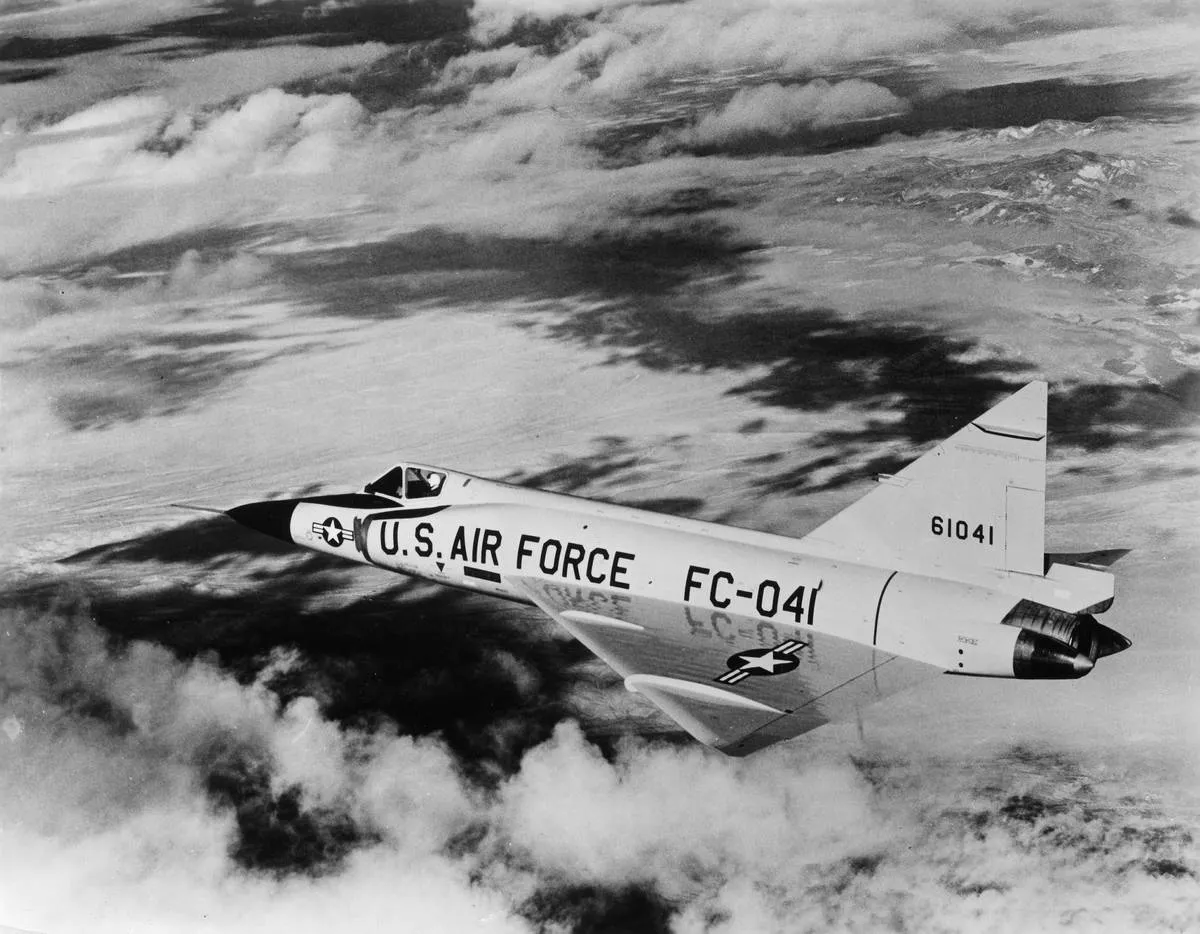 The Convair F-102 'Delta Dagger' is flying near clouds.