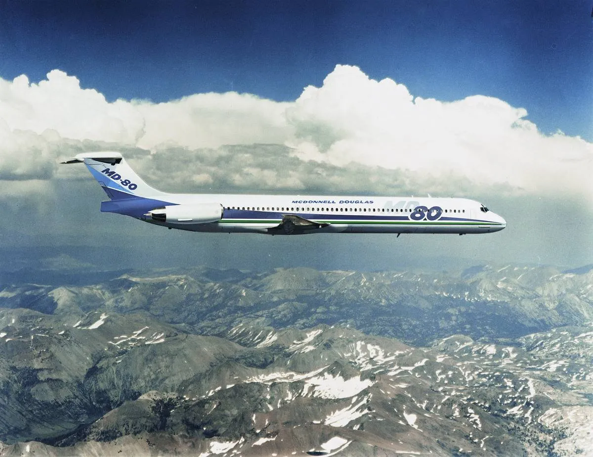 A McDonnell Douglas MD-80 flies over a mountain range.