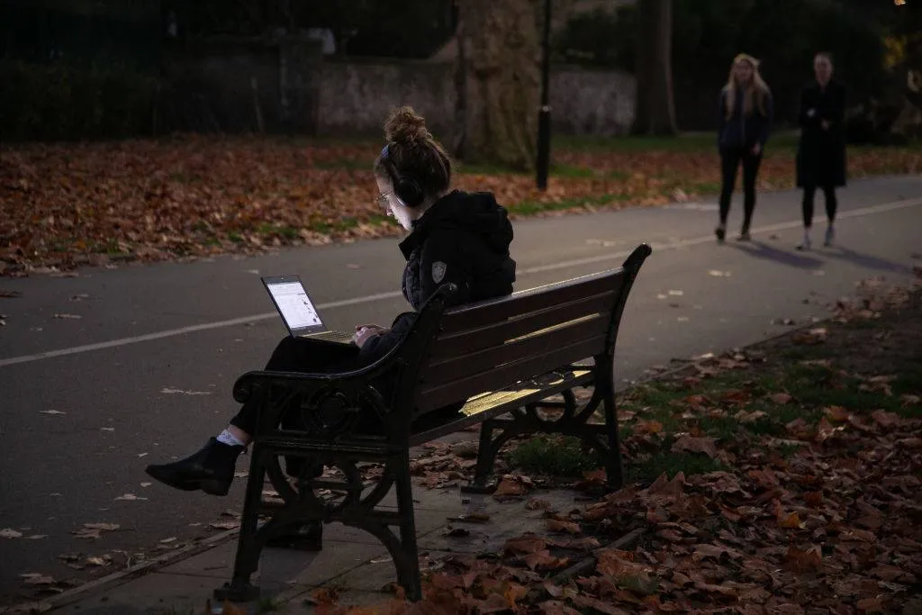 Woman in a park on her computer 