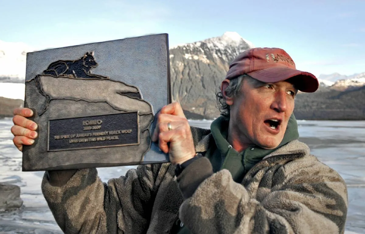 Author Nick Jans holds up a plaque made for Romeo the wolf.