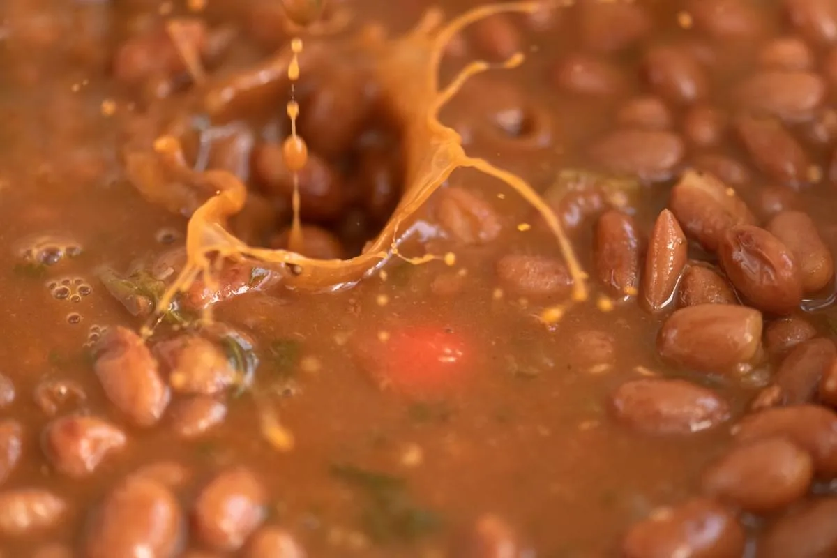 Red kidney beans soup with small splashes of grains falling...
