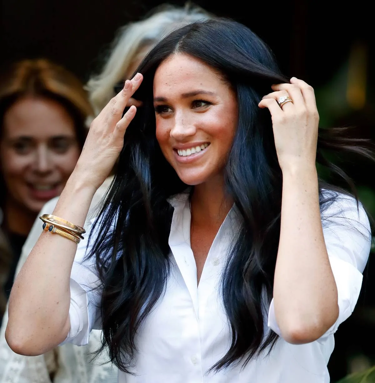 Meghan Markle's bracelets are seen as she moves her hair out of her face.