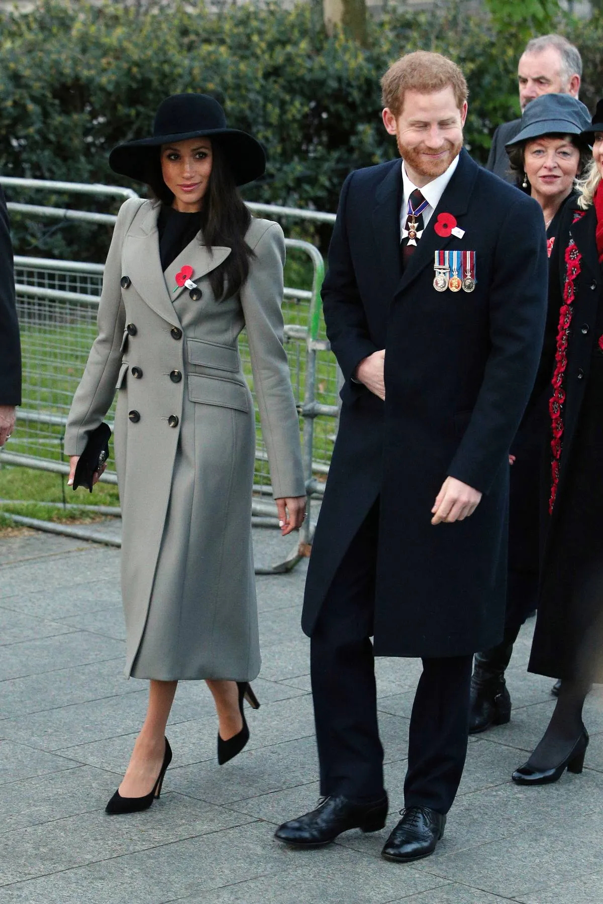 Meghan Markle walks with Prince Harry to Hyde Park, while she wears a black hat and grey coat.