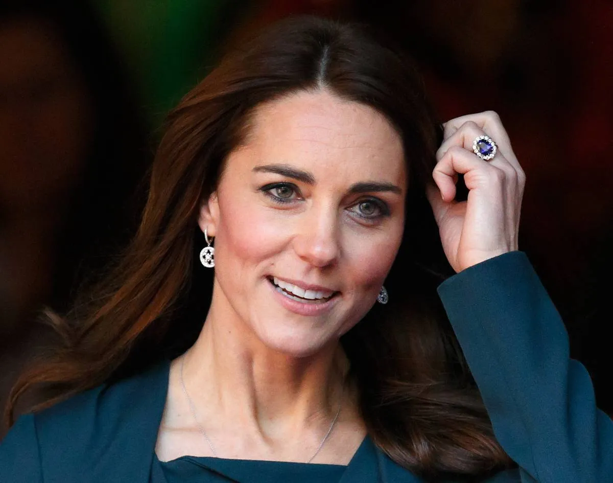 Kate Middleton shows off her wedding ring while touching her hair.