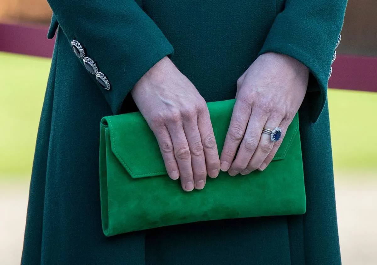 Kate Middleton carries a bright green clutch that goes with her outfit.