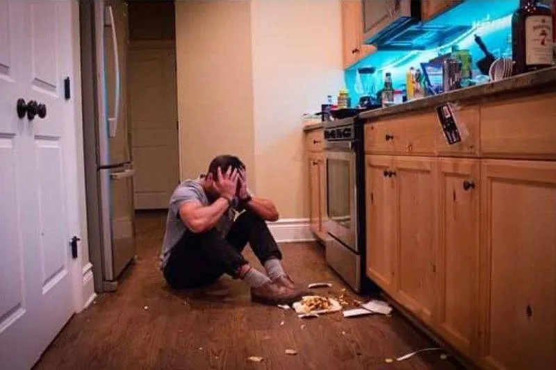 a guy sitting on the kitchen floor crying because he dropped his burrito 