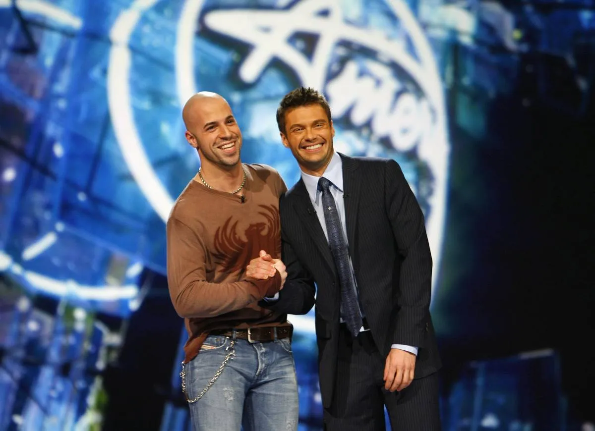 Chris Daughtry shakes hands with Ryan Seacrest on the American Idol stage.