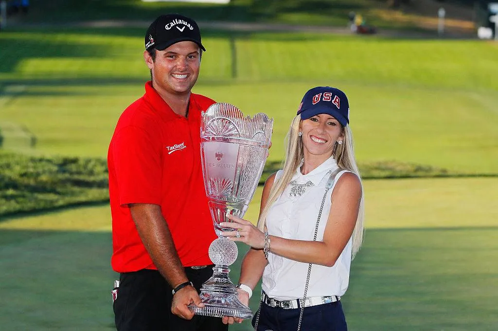Patrick Reed poses with his wife Justine and the trophy after winning The Barclays