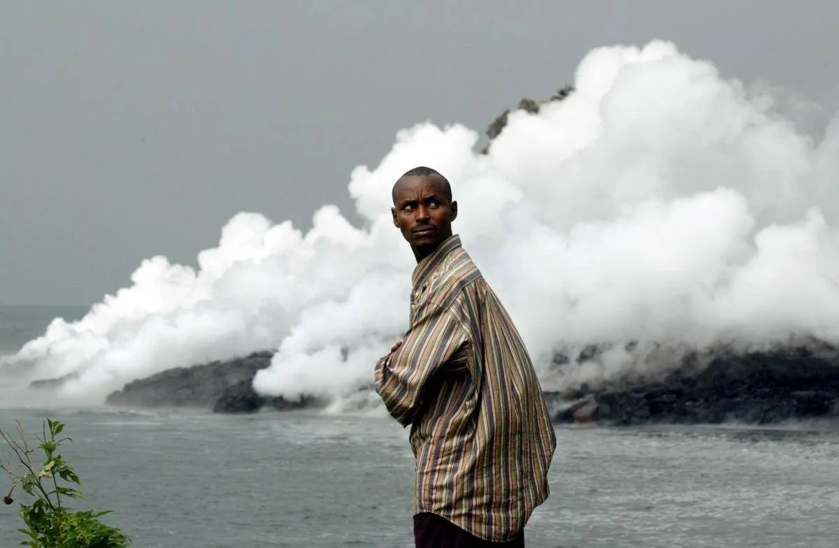 A man stands by Lake Kivu, which steams as lava from the nearby volcano Niragongo pours in.