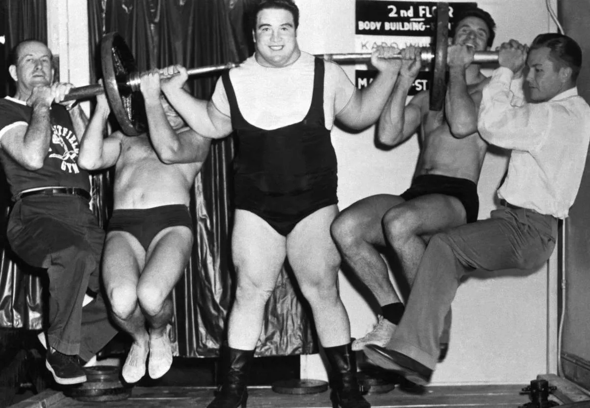 Paul Anderson Lifting Men on Barbell
