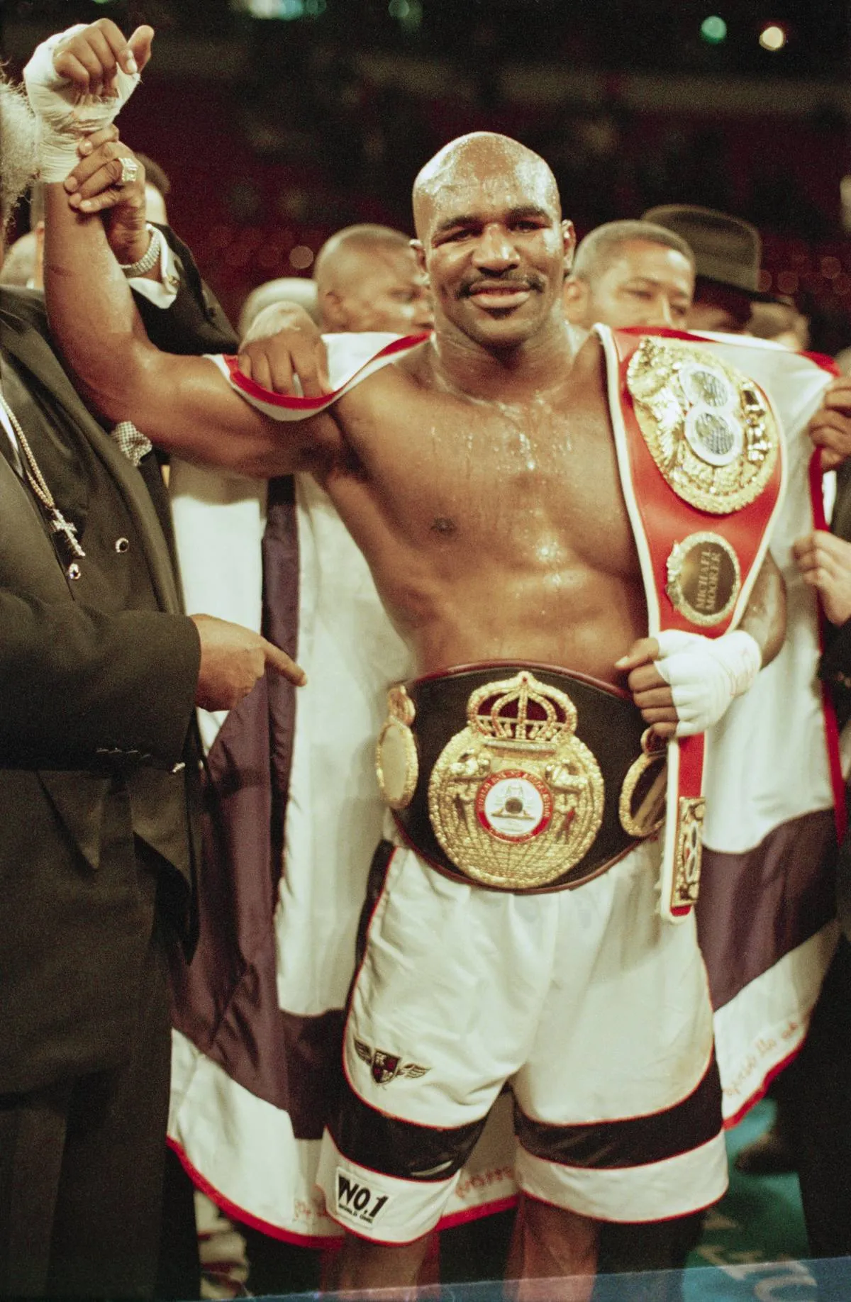 American boxer Evander Holyfield carries his belt after winning the fight against Michael Moorer in Las Vegas, 8th November 1997