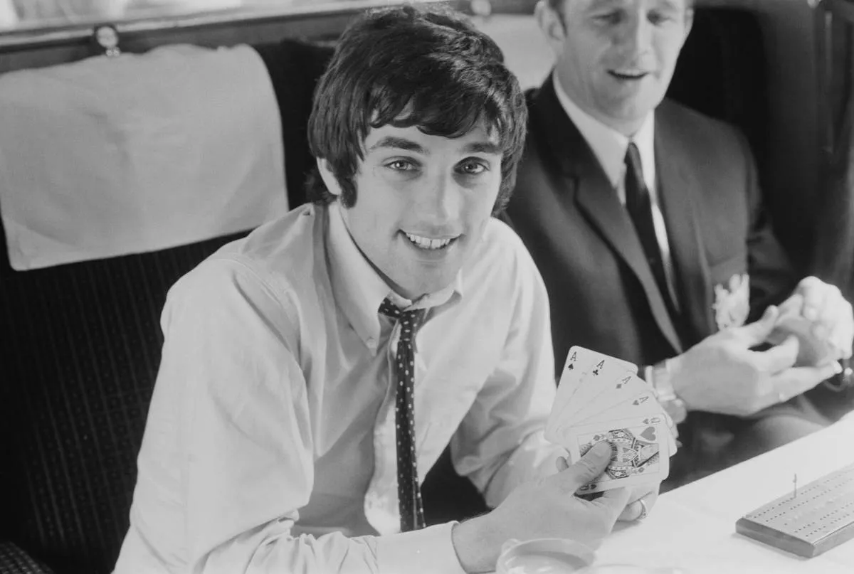 Manchester United FC soccer player George Best (1946 - 2005) plays poker on a train, UK, 27th May 1968