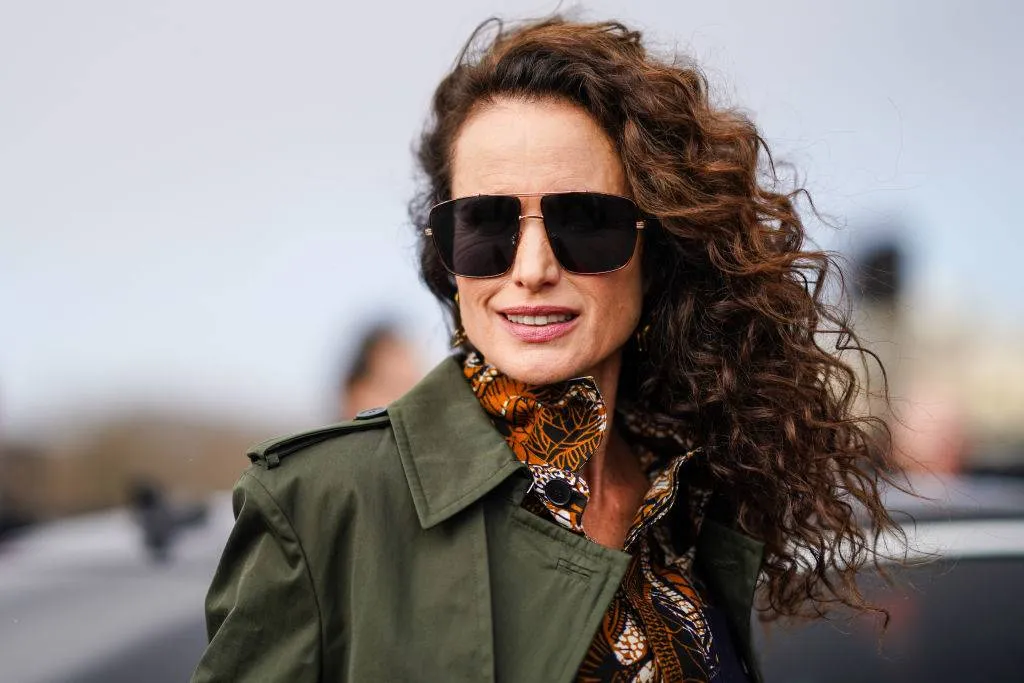 Andie MacDowell wearing a green coat and sunglasses