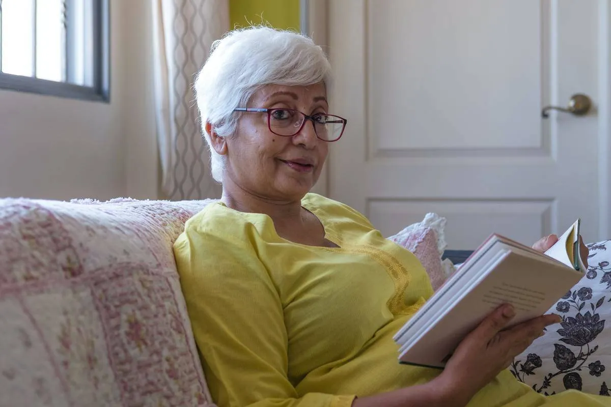 a woman with red glasses reading a book