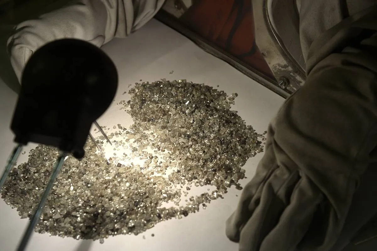 A person sorts through a pile of tiny diamonds.