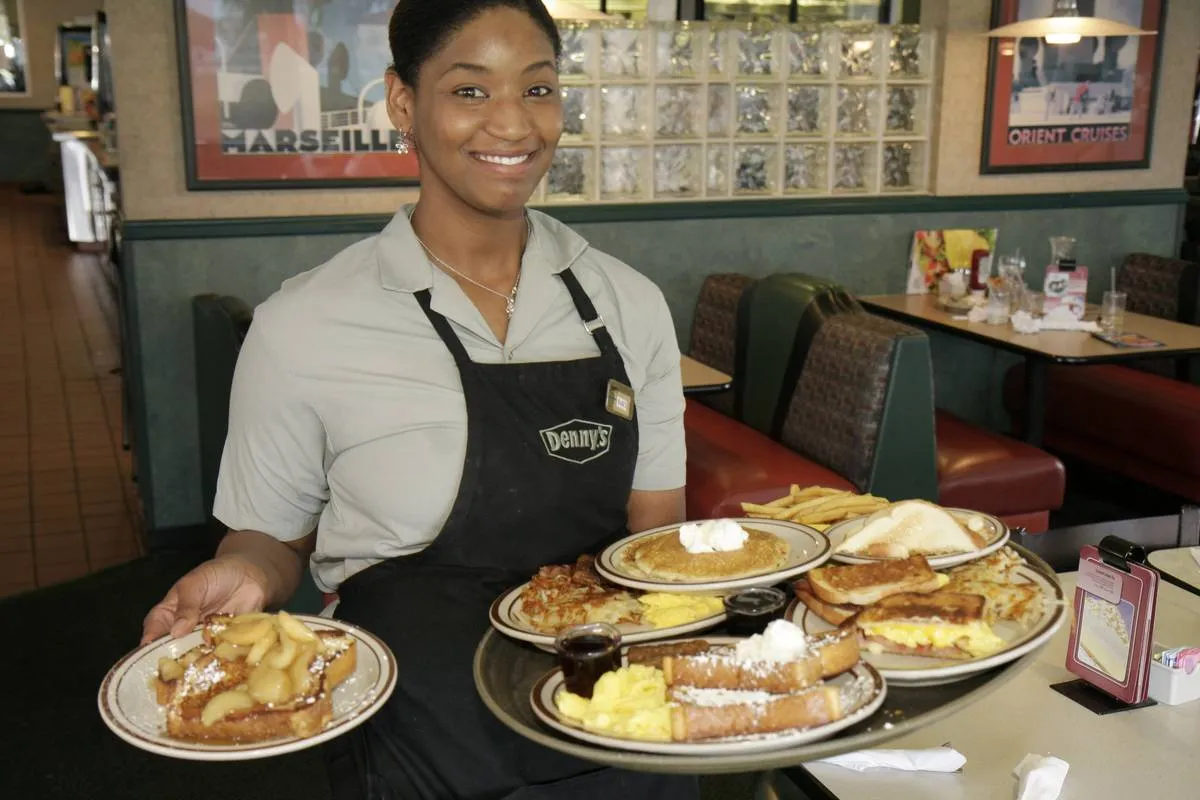 A waitress serving food at Denny's Restaurant.