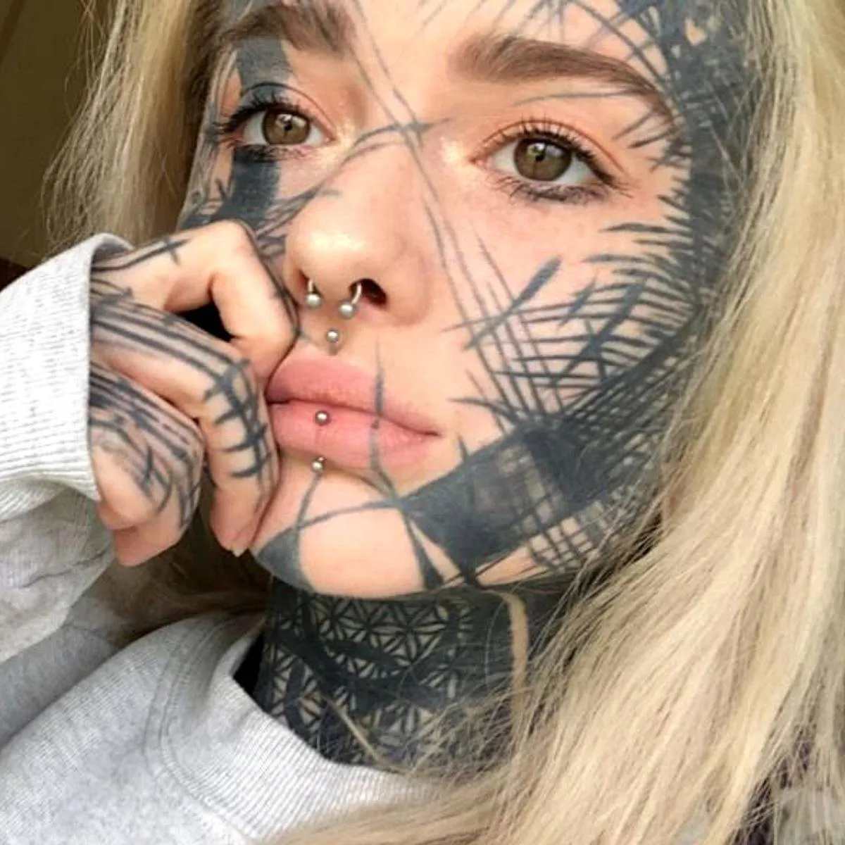 blonde girl with crisscrossing face tattoo