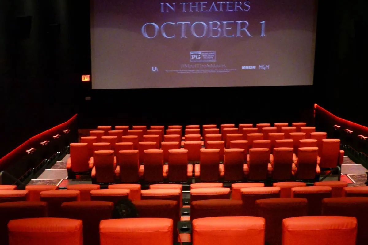 Rows of empty seats in Movie Theater with film screen that says: In Theatres October 1