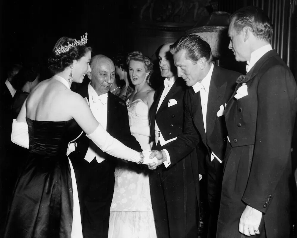 The queen meets party guests in a black and white photo taken at event