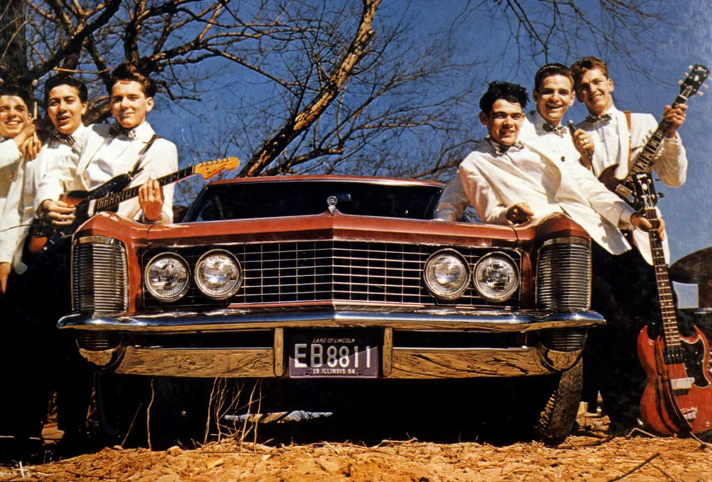 The Rivieras band posed leaned on car with electric guitars