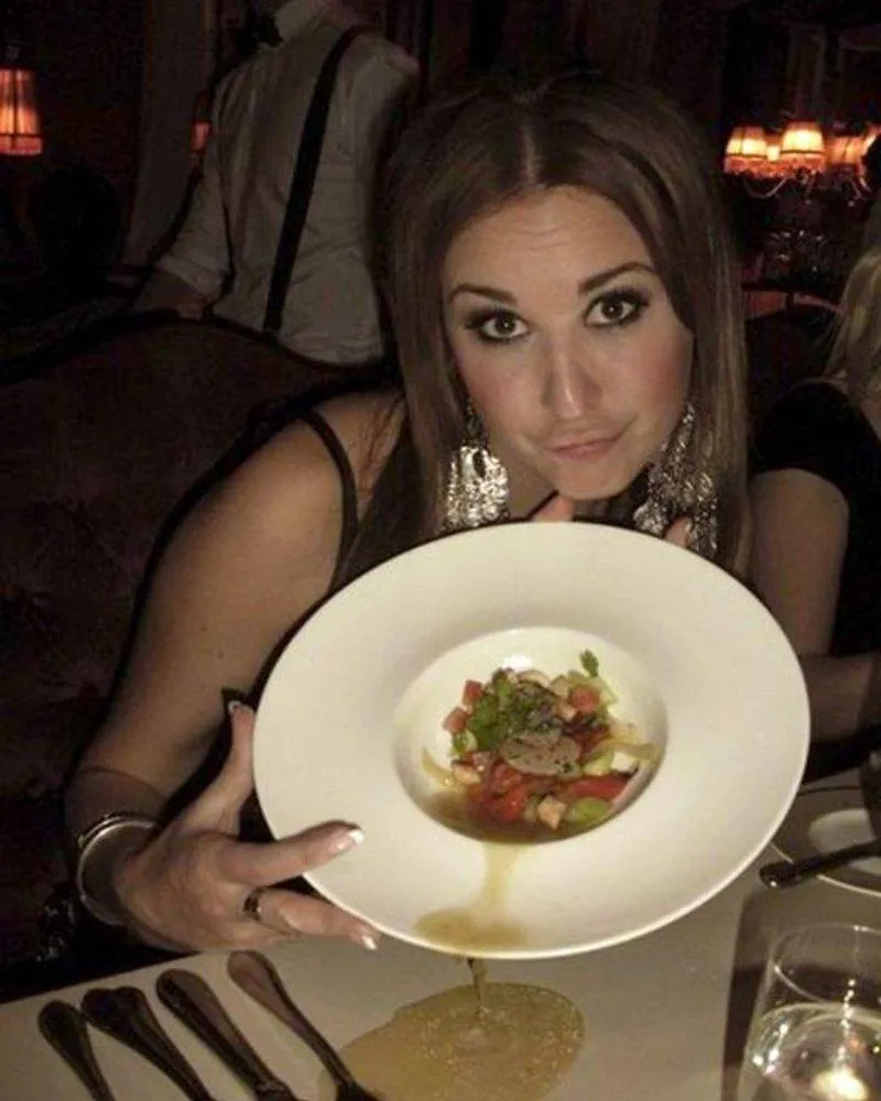 Woman showing off her food at restaurant and all of it spilling onto the table