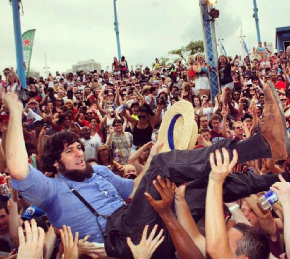 amish man crowd surfing at a concert