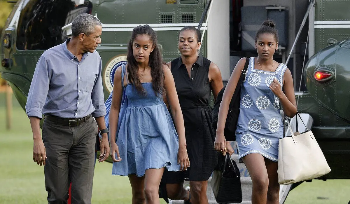 US President Barack Obama (L), daughters Sasha (R), Malia (2nd L) and wife Michelle arrive at the White House in Washington, D.C on August 23, 2015 upon their return from vacationing at Martha's Vineyard. 