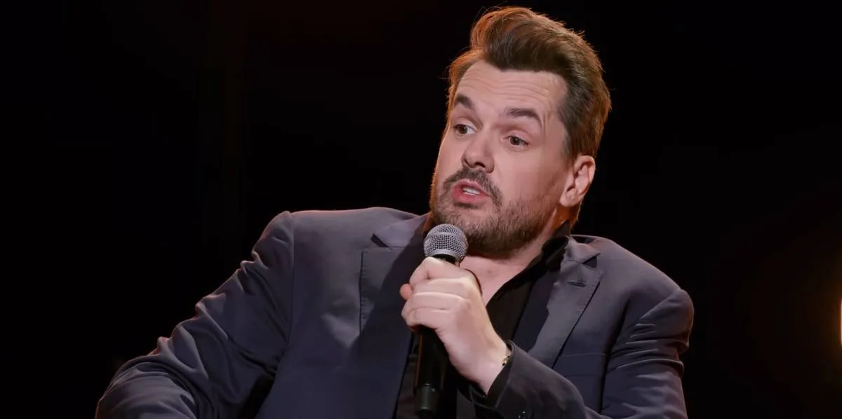 Jim Jeffries speaking into microphone while sitting down in Intolerant